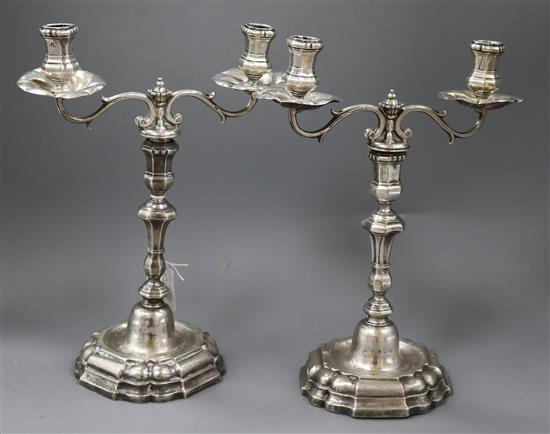 A pair of 19th century Spanish? white metal two branch, two light candelabra, gross 48.5cm.